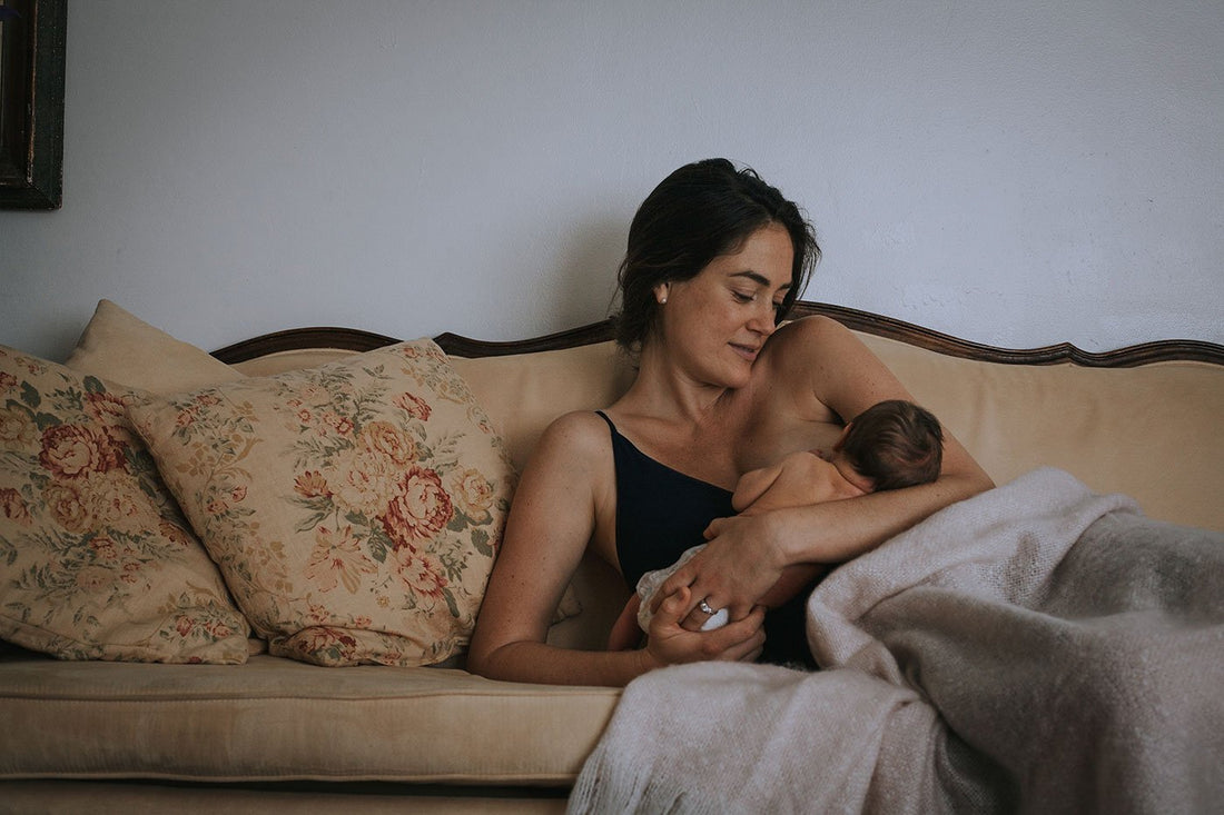 mom-breastfeeding-baby-in-her-arms-on-couch