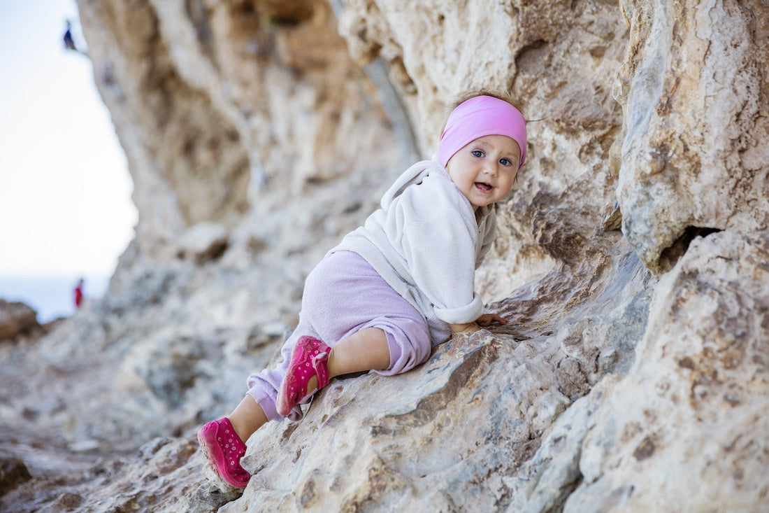A brave baby scales some rocks