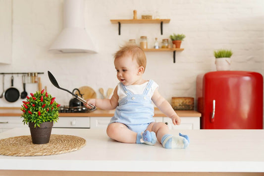 Food inspired baby names - baby boy sitting on kitchen counter holding spoon