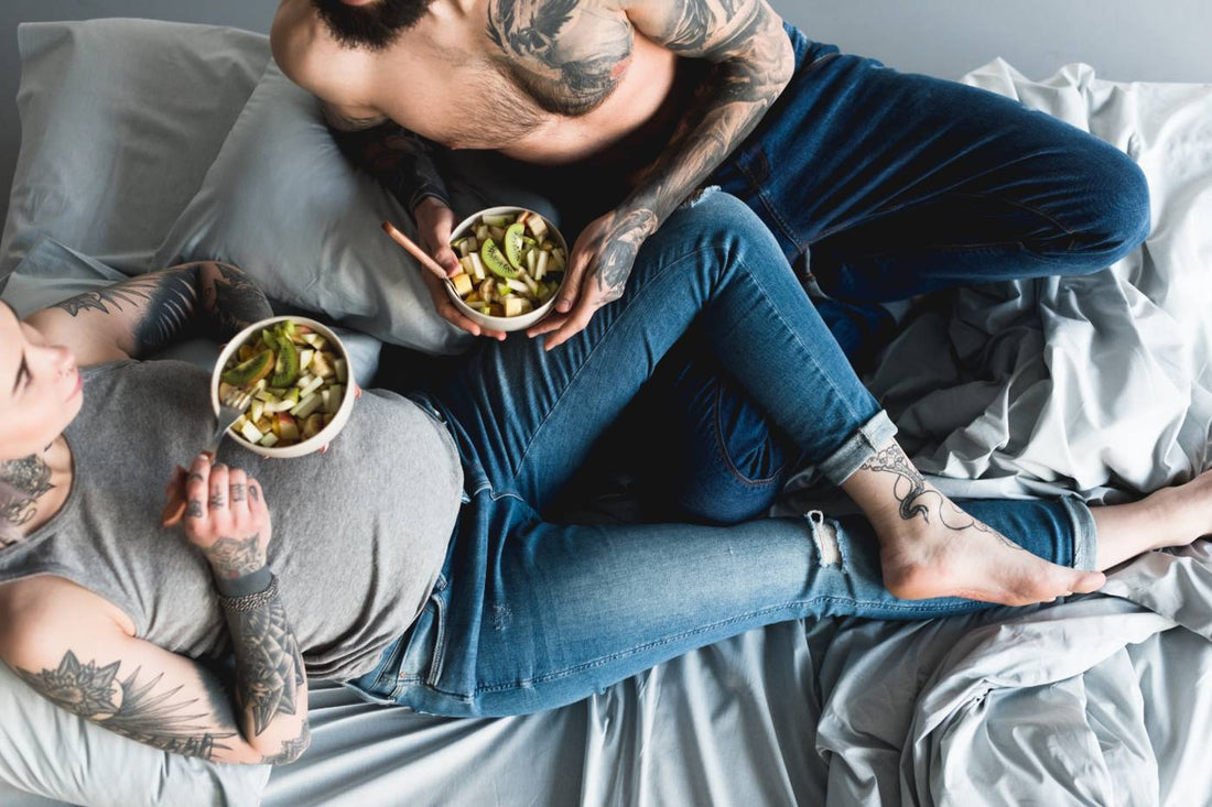 Pregnant woman eating salad on bed