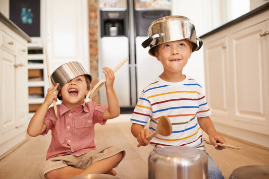 Toddlers playing music in the kitchen