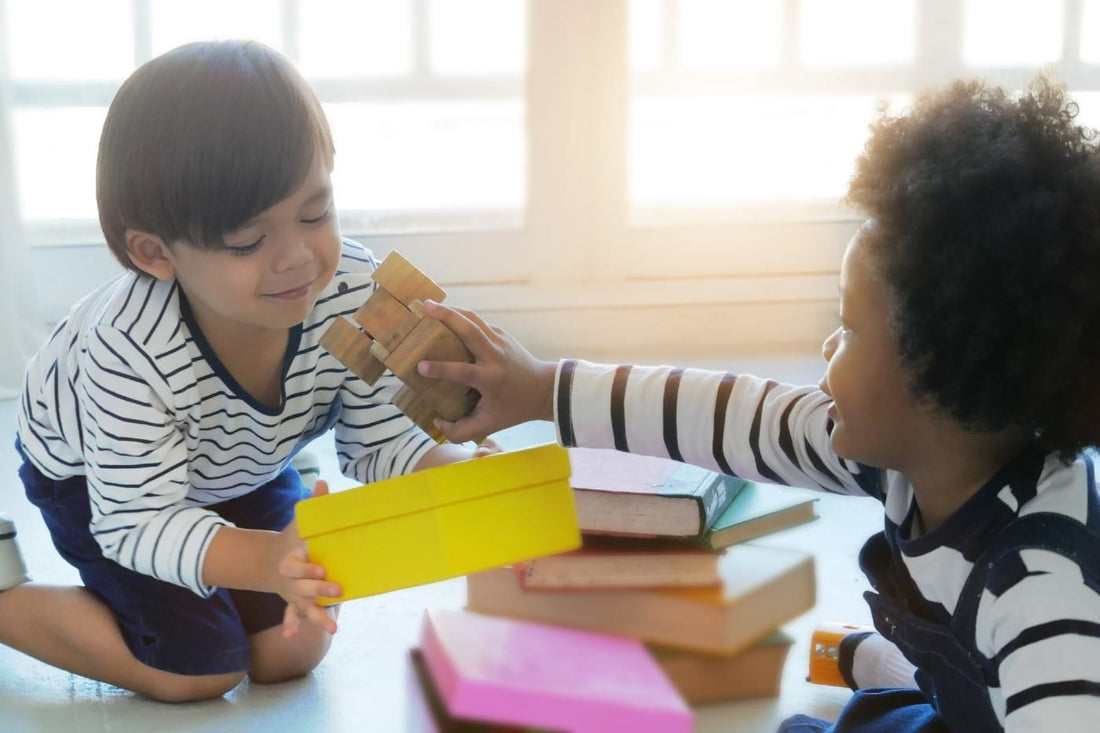 Two toddler boys sharing toys in a preschool classroom.