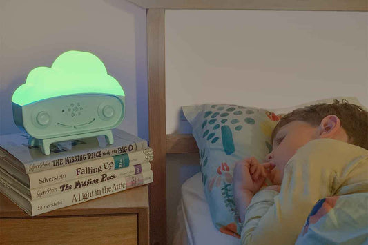 A child sleeps next to a SNOObie nightlight