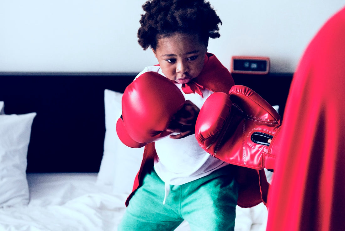 Toddler boy dressed in boxing gloves