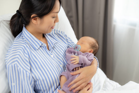 New mum holds her newborn as she recovers from a c-section