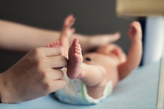 parent changing newborn in nappy first poop