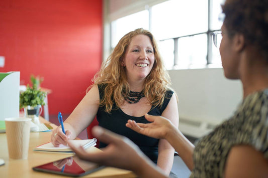 New mom chatting with coworker after returning from parental leave