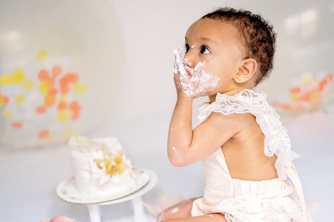 Baby girl eating a smash cake.