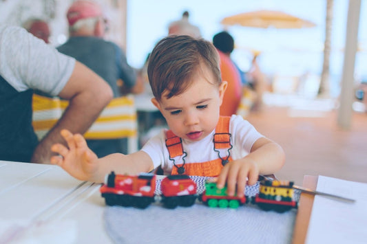 Toddler boy plays with a train