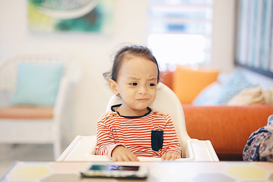 Toddler tantrum triggers: Unhappy toddler in highchair