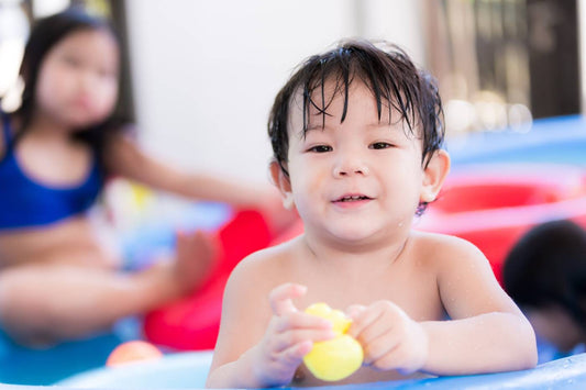 toddler boy swimming in a pool 